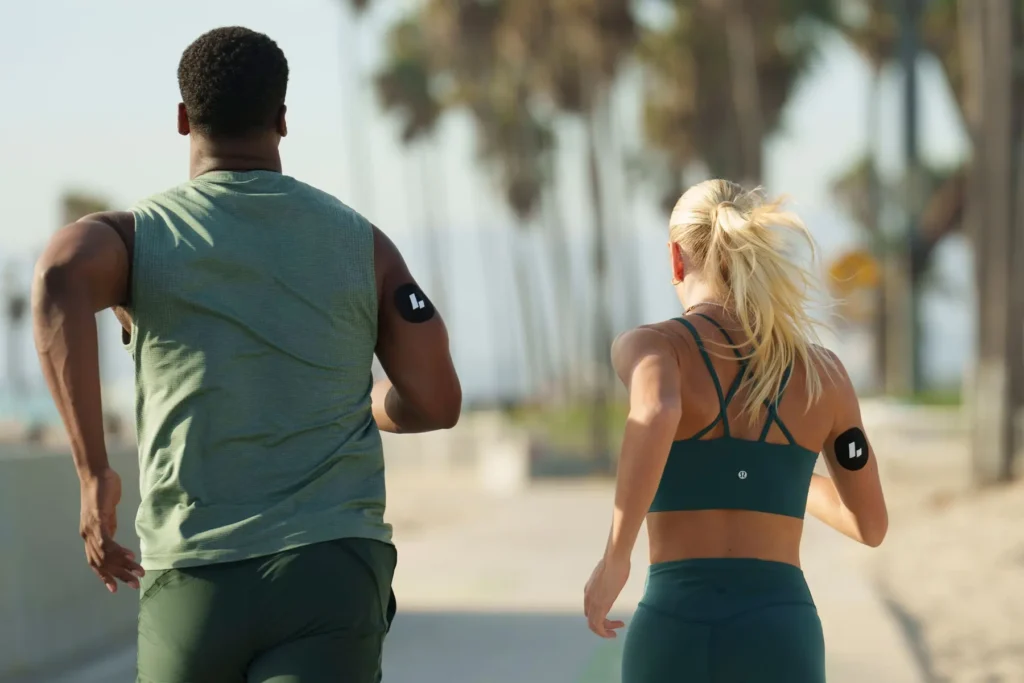 Two people running with bio hacking sensors to monitor metabolic health and cellular energy optimization