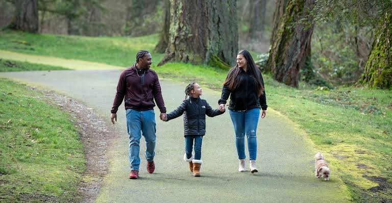 Sound Health and Wellness Trust promoting family wellness through a healthy outdoor walk in a peaceful park.